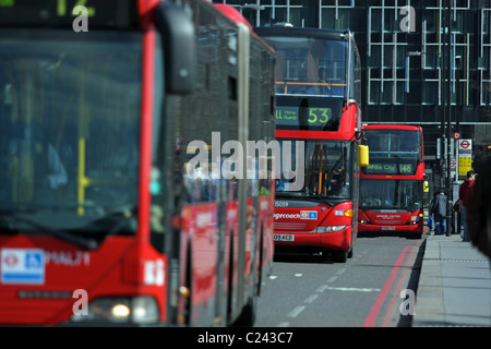 Mehrere rote Londoner Bussen reisen entlang einer Straße in London, England Stockfoto