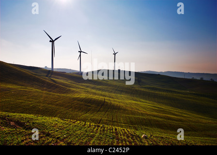 Drei Wind-Turbinen-Silhouetten auf Hügel Stockfoto