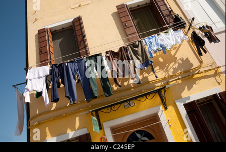 Wäsche trocknen auf der Linie auf ein gelbes Haus, Burano Dorf, Venedig, Italien Stockfoto