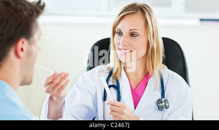 Attraktive Ärztin eine Speichelprobe eines männlichen Patienten mit Wattestäbchen Einnahme Stockfoto