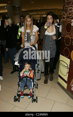 X-Factor "Finalist Stacey Solomon mit einer Polizei zu begleiten, wie sie mit ihrer Schwester Gemma Solomon im Lakeside Shopping Centre Geschäfte Stockfoto