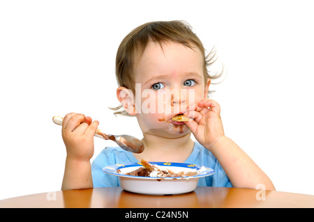 Schöne blaue Augen Baby essen Eis mit einem Löffel, isoliert in weiß Stockfoto