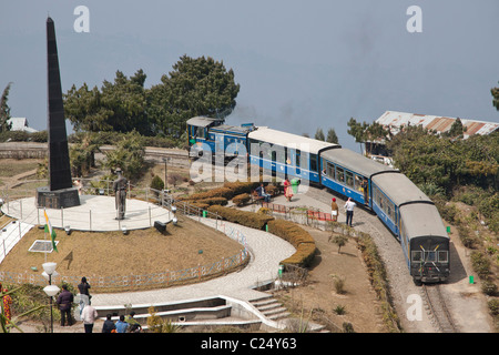 Die Spielzeugeisenbahn durchläuft Batasia Loop und das Kriegerdenkmal in Darjeeling, Westbengalen, Indien. Stockfoto