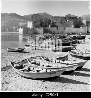 Fischerboote aus den 1950er Jahren, die am Strand am mittelalterlichen Chateau Royal de Collioure im Küstendorf Collioure in Südfrankreich festgemacht wurden. Stockfoto