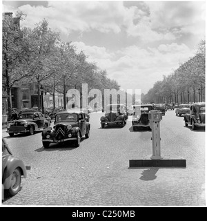 Frankreich, 1950er Jahre. Die Autos der Ära fahren Sie auf der berühmten gepflasterten Avenue, der Champs-Elysees in der Nähe des Arc de Triomphe in Paris. Stockfoto