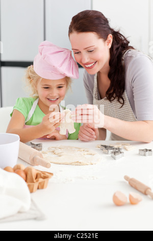 Fröhliche Mutter und Tochter machen Cookies in Gestalt eines Mannes Stockfoto