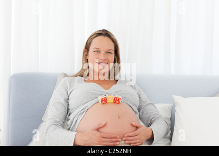 Porträt einer schwangeren Frau mit Mutter Briefe auf ihren Bauch Stockfoto