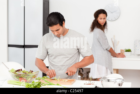 Konzentriert Man schneiden von Gemüse mit seiner Freundin Stockfoto