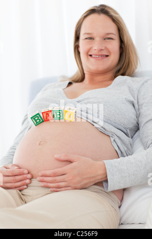 Süße schwangere Frau mit Baby auf dem Bauch Stockfoto