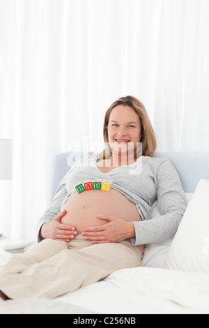 Porträt einer schwangeren Frau mit Mutter Briefe auf ihren Bauch Stockfoto