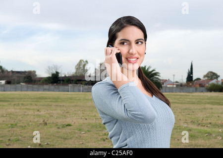 Weibliche Studenten auf dem Campus telefonisch unter Stockfoto