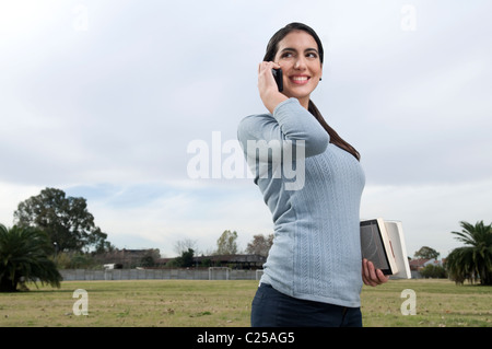 Weibliche Studenten auf dem Campus telefonisch unter Stockfoto