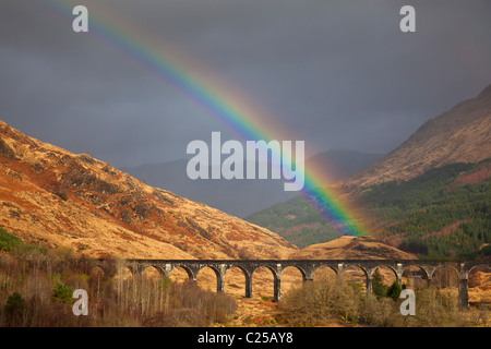 Ein Regenbogen wölbt sich über berühmte konkrete Glenfinnan Eisenbahnviadukt überspannt die Glen auf Fort William in Mallaig Zeile Stockfoto