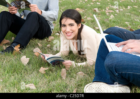 Lady, Frau, Mädchen, sitzen, gelegen, Blick auf, der, Kamera, Ansicht, lesen, lesen, verwenden, Notebook, Mac, sitzen, unten, festzulegen, legen Stockfoto