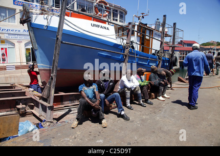 SCHWARZE farbige Arbeiter sitzen in der Nähe Angeln Boot ST. FRANCIS Hafen EASTERN CAPE in Südafrika 26. Januar 2011 Stockfoto