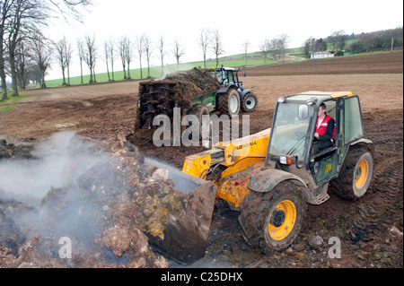 Muckspreader mit einem JCB Loadall be- Stockfoto