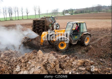 Muckspreader mit einem JCB Loadall be- Stockfoto