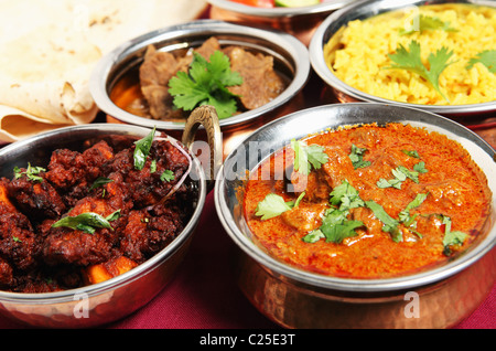 Hähnchen braten (links) und Kashmiri Lamm curry (rechts) vor Chapattis, Rindfleisch Korma und Safranreis. Stockfoto