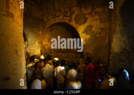 Touristen gehen vorbei an eine Nische mit einem Grab des Hl. Nikolaus in der Basilika in Myra. Stockfoto