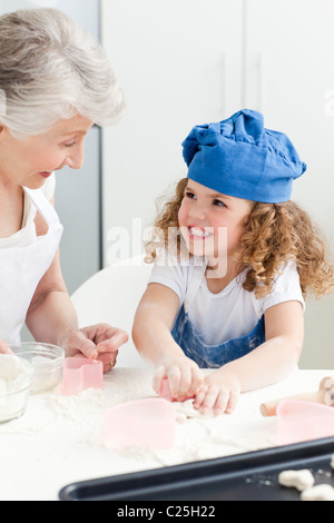 Ein kleines Mädchen mit ihrer Großmutter Backen Stockfoto