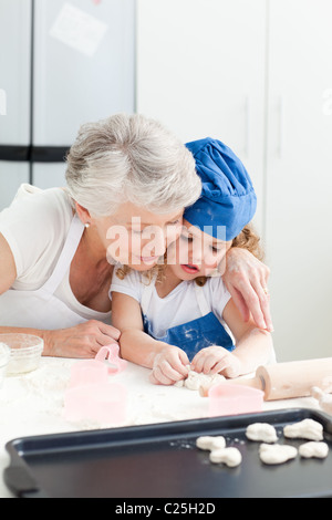 Ein kleines Mädchen mit ihrer Großmutter Backen Stockfoto