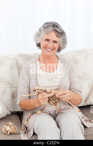 Ältere Frau stricken auf ihrem sofa Stockfoto