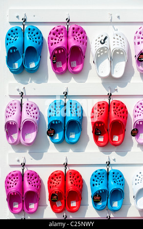 Rack mit bunten Plastik Kinder Schuhe (Crocs) hängend auf einem display Stockfoto