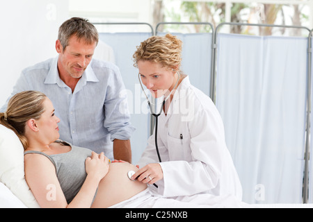 Schwangere Frau mit ihrem Ehemann die Krankenschwester anhören Stockfoto