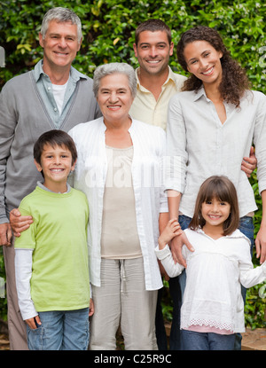 Porträt einer glücklichen Familie schaut in die Kamera im Garten Stockfoto