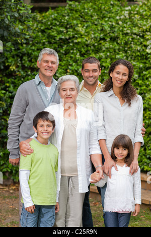 Porträt einer glücklichen Familie schaut in die Kamera im Garten Stockfoto