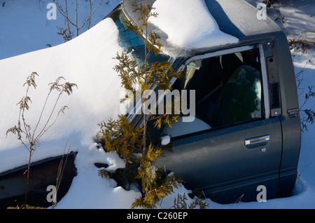 Frischer Schnee bedeckt ein verlassenes Auto Taxi halbieren an einem frostigen Wintermorgen Stockfoto