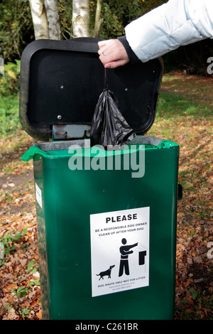 Eine Tasche von Hundehaufen in einem Pfad Seite Hund bin in Black Park Country Park, Wexham, UK hinterlegt wird. Stockfoto