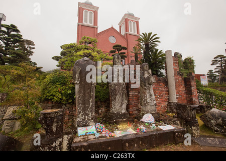 Statuen und Frieden Zeichnungen nass vom Regen, mit Urakami Kathedrale im Hintergrund, in Nagasaki, Kyushu, Japan. Stockfoto