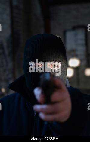 Mann/Terrorist trug eine schwarze Sturmhaube, eine Pistole auf den Betrachter gerichtet Stockfoto