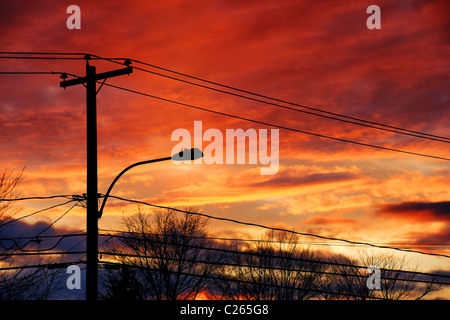 Sonnenuntergang über den Strom Post und Kabel einer Kleinstadt. Stockfoto