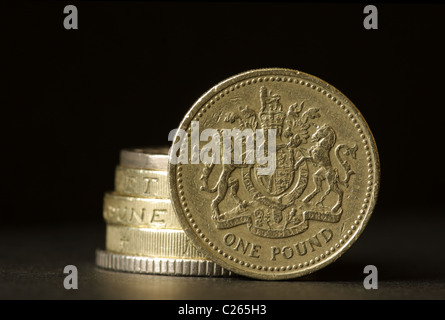 Ein Stapel von britischen Münzen mit einem Pfund-Münze auf der Kante stehen. Stockfoto