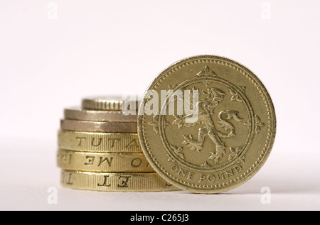 Ein Stapel von britischen Münzen mit einem Pfund-Münze auf der Kante stehen. Stockfoto