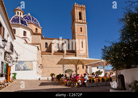 Altea Hauptplatz mit Restaurant und Bar-Terrassen im Tageslicht und der Turm und seine blaue Kirchenkuppel im Hintergrund Stockfoto