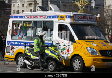 Eine Gemeinschaft Unterstützung Offizier teilen einen Witz mit einem Eis-Verkäufer in einem Eiswagen auf Westminster Bridge, London, England Stockfoto