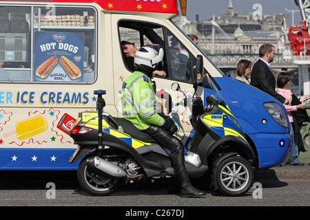 Eine Gemeinschaft unterstützen Offizier im Gespräch mit einer Eis-Verkäufer in einem Eiswagen auf Westminster Bridge, London, England Stockfoto