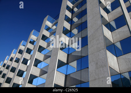 moderne symmetrische Bürogebäude Fassade mit reflektierenden Windows vor einem blauen Himmel Stockfoto