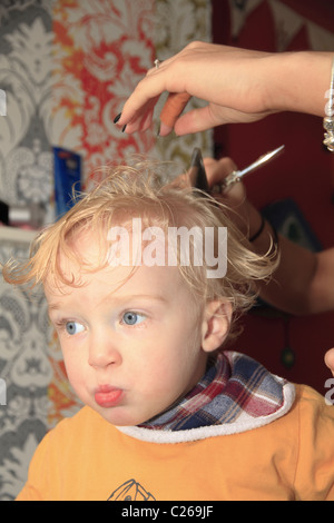 Ein Kleinkind mit seinem ersten Haarschnitt. Stockfoto