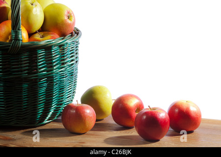 Äpfel im Korb auf alten Balken auf weißem Hintergrund Stockfoto