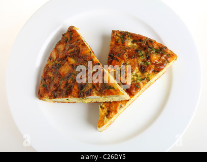 Scheiben von spanisches Omelett oder Tortilla de Patatas auf einem weißen Teller, von oben gesehen Stockfoto