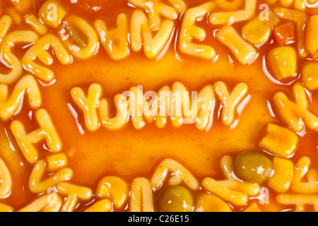 Alphabet geformten Nudeln bilden das Wort YUMMY in Tomatensauce Stockfoto