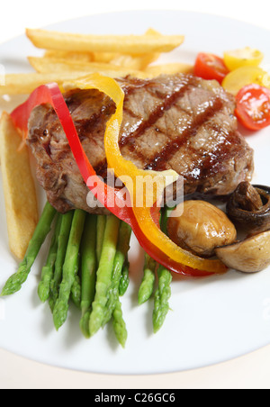 Kalbfleisch-Sirloin-Steak, serviert mit gegrillten Champignons, Spargel, Cherry Tomaten, Bänder, rote und gelbe Paprika und Pommes Frites. Stockfoto