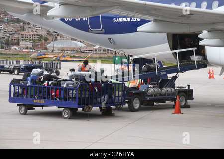 Gepäckabfertiger am Flughafen laden das Gepäck in den Flugzeug-Bauch Stockfoto