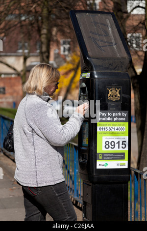 Frau bezahlen für das Parken auf einem Meter in Nottingham City centre Nottinghamshire England GB UK EU Europe Stockfoto