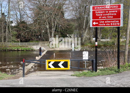 Zwei Personen und einem Hund bei Ford und Trittsteine, die Überquerung des Flusses tragen bei Stanhope im Nordosten Englands Stockfoto