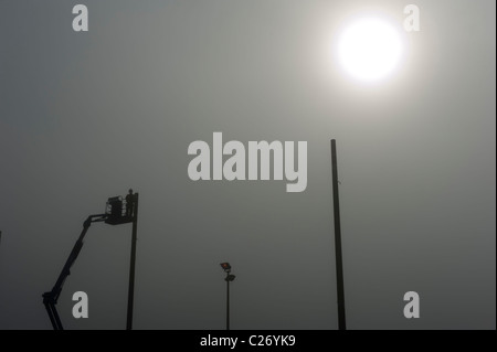 Silhouette der Bauarbeiter auf einem kleinen Kran Stockfoto